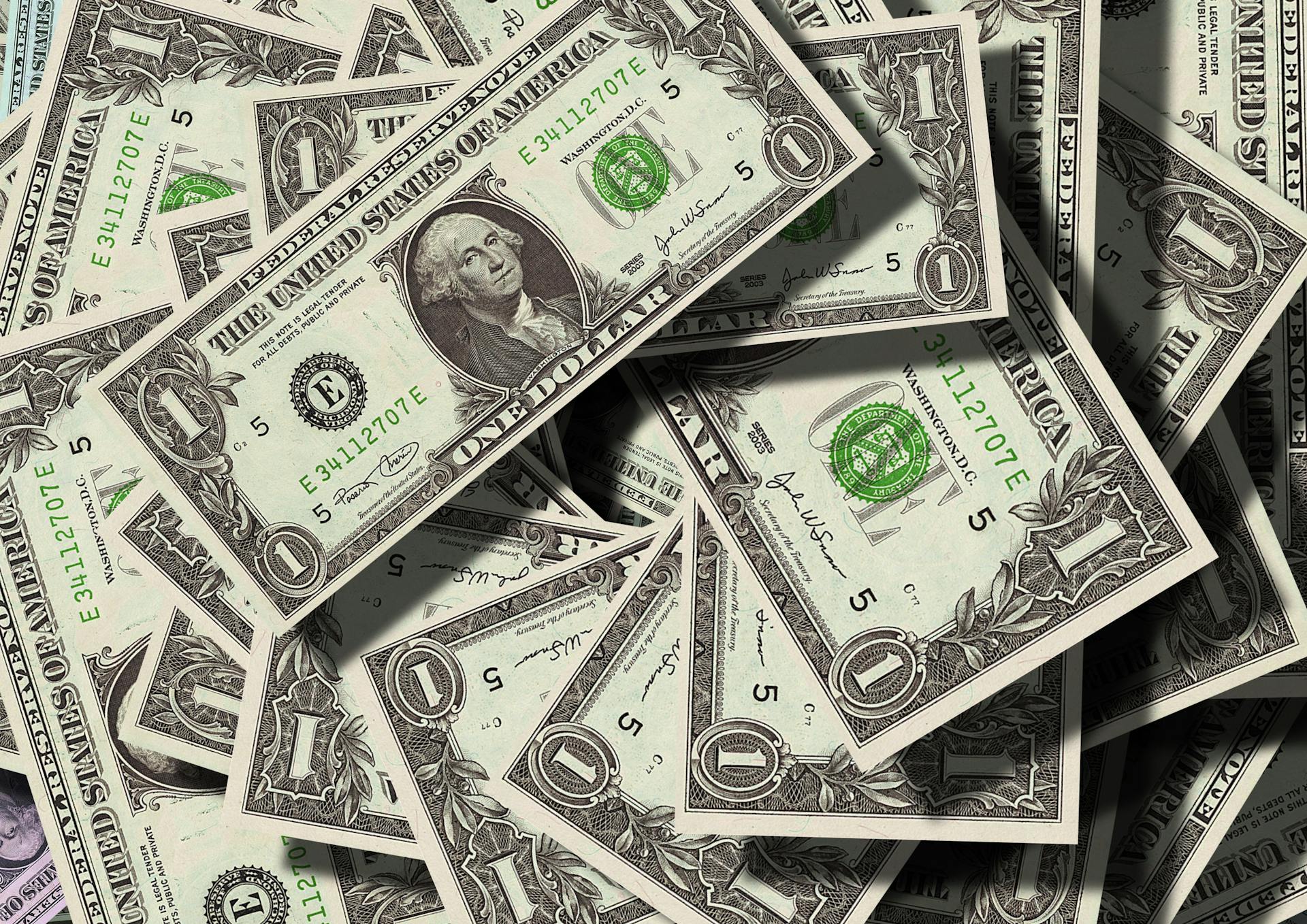 US dollar bills in a messy pile