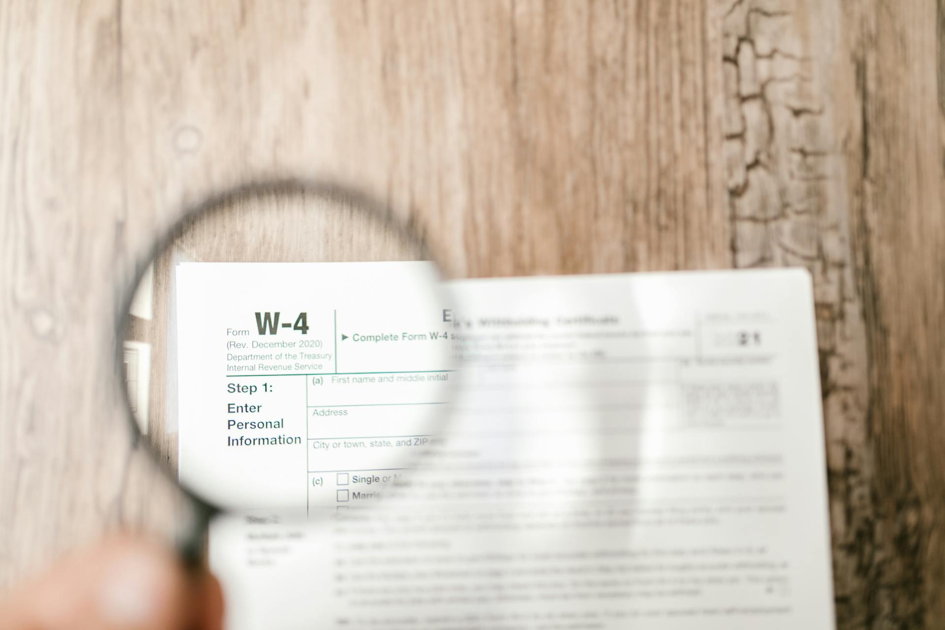 magnifying glass over w-4 tax withholding form