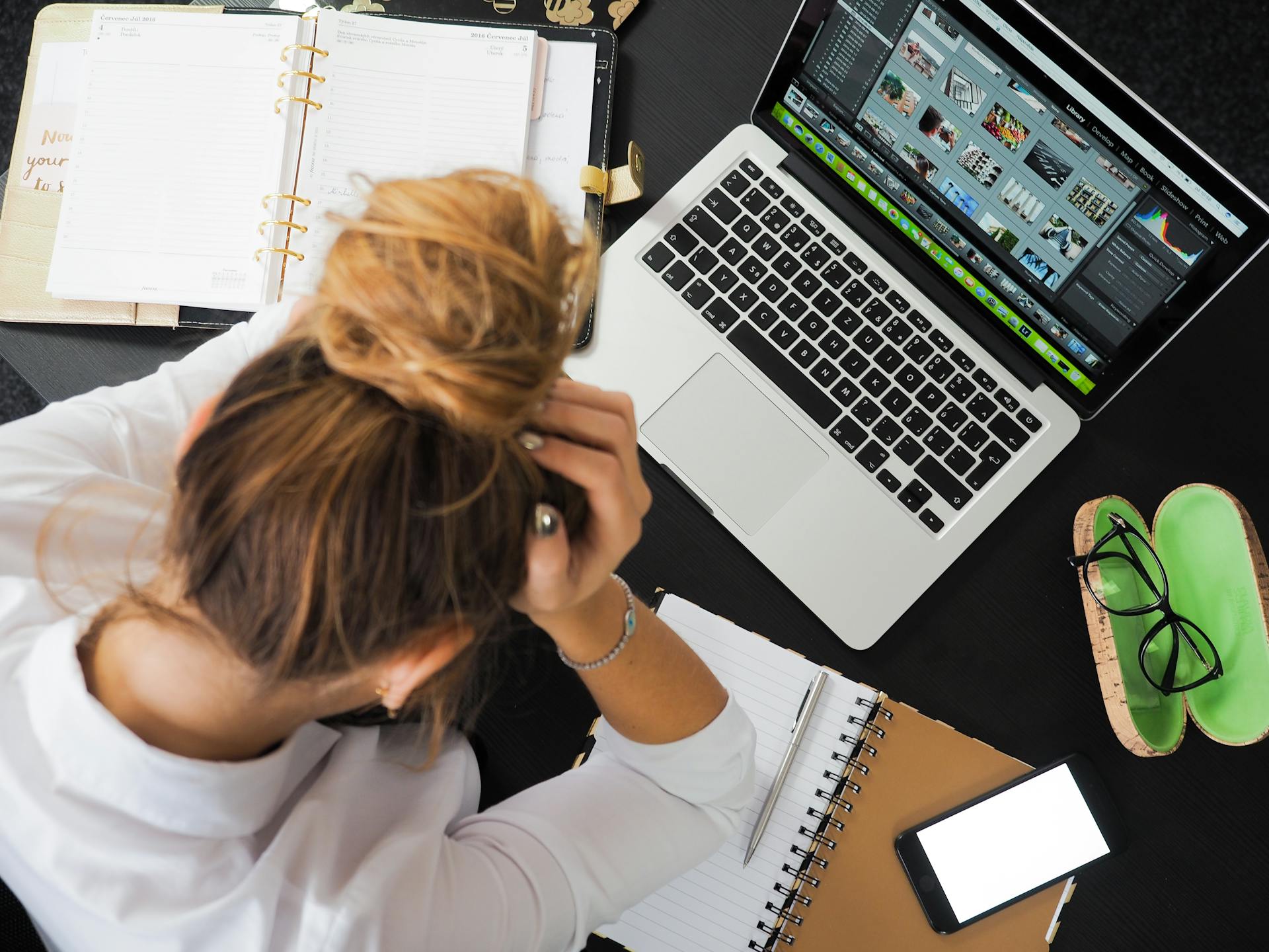 woman sitting at computer with head in hands